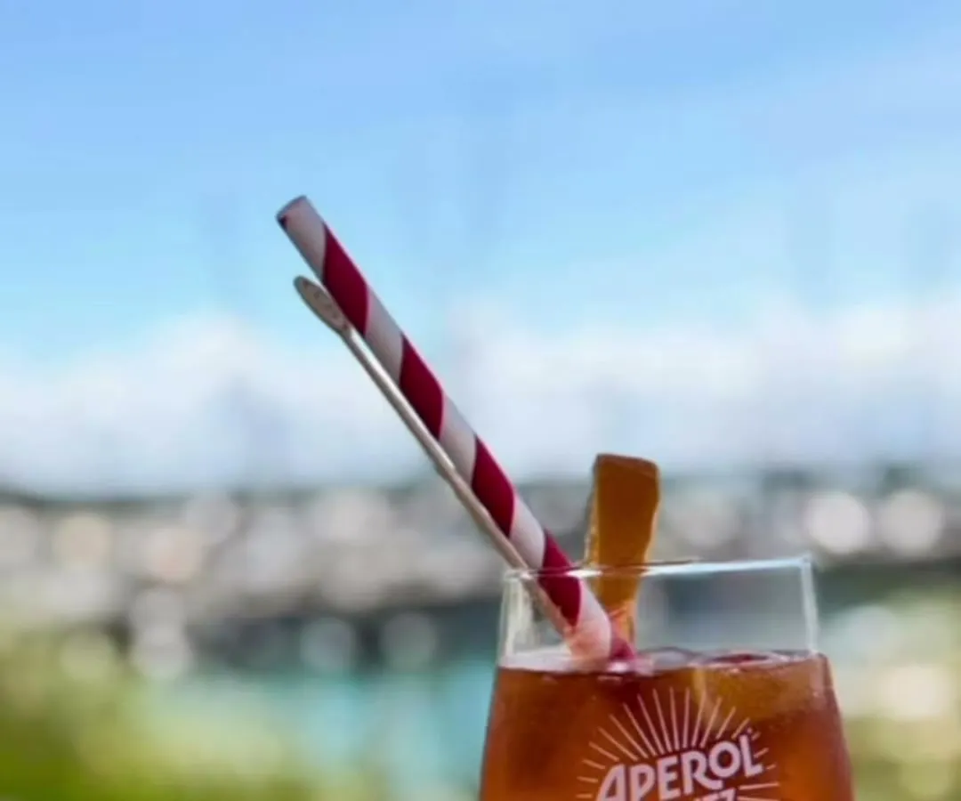 Un spritz posé sur la terrasse, le port en arrière-plan