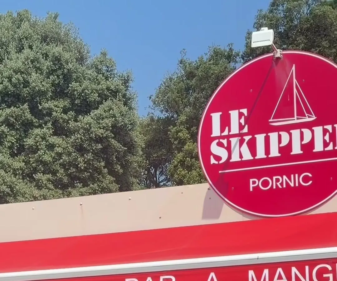 L’enseigne ronde rouge du Skipper au-dessus de l’auvent « Bar à manger »